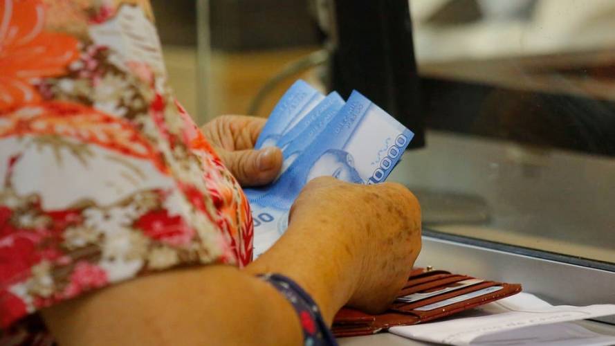 Señora con billetes en la caja