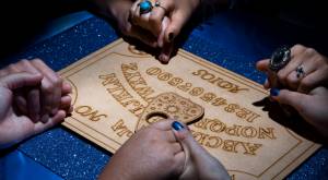 Manos de jóvenes sobre una tabla Ouija