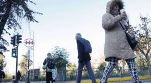 Personas caminando abrigadas en Santiago